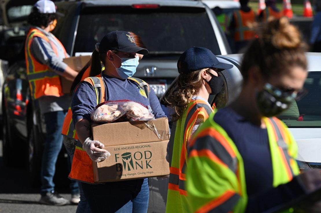 Volunteers load free groceries into cars for people experiencing food insecurity due to the pandemic, December 1, 2020, in LA. Helping other people within your community is a form of spiritual rest.