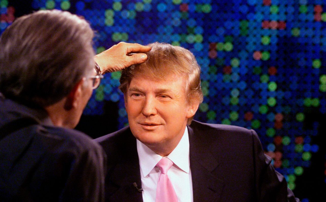 King touches Donald Trump's hair during an <a href="https://www.cnn.com/videos/entertainment/2015/08/27/donald-trump-larry-king-live-president-hair-comb-over-bts.cnn" target="_blank">interview in 2004.</a>