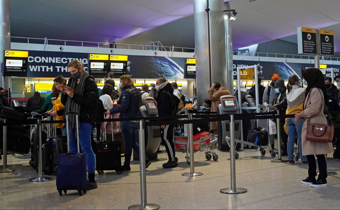 Passengers queue at a check-in desk at Heathrow Airport in London on December 21.