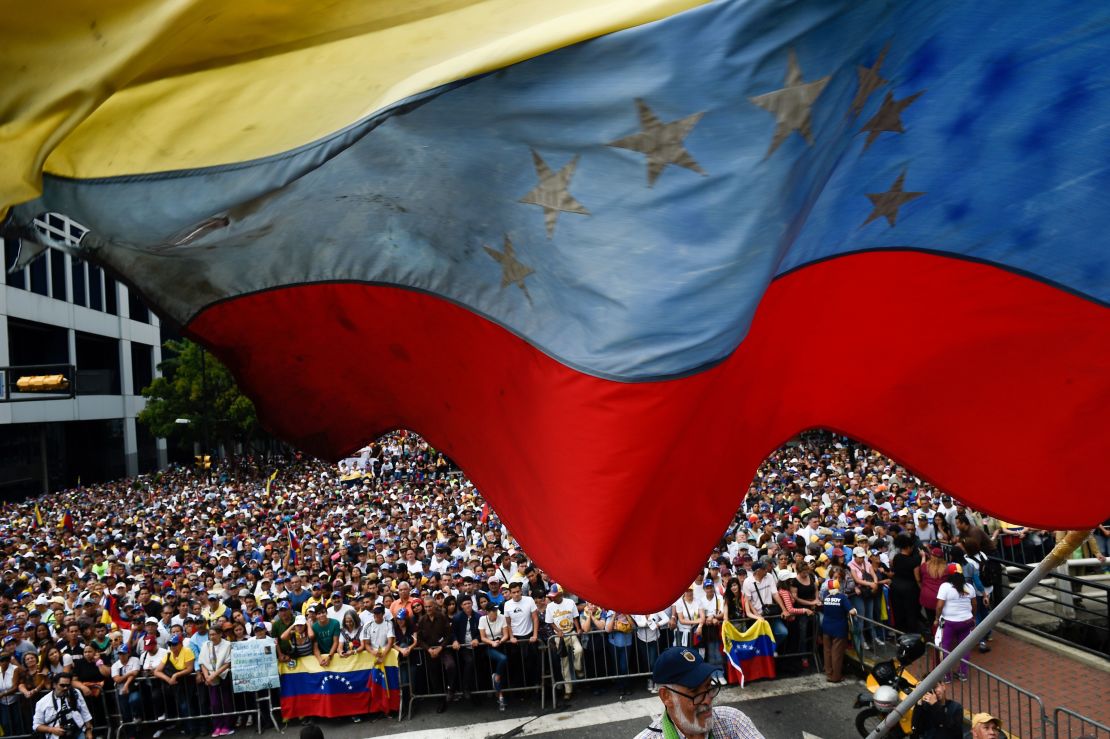 A Venezuelan national flag flutters during a mass opposition rally against President Nicolas Maduro in which Venezuela's National Assembly head Juan Guaido (out of frame) declared himself the country's "acting president", on the anniversary of a 1958 uprising that overthrew a military dictatorship, in Caracas on January 23, 2019. 