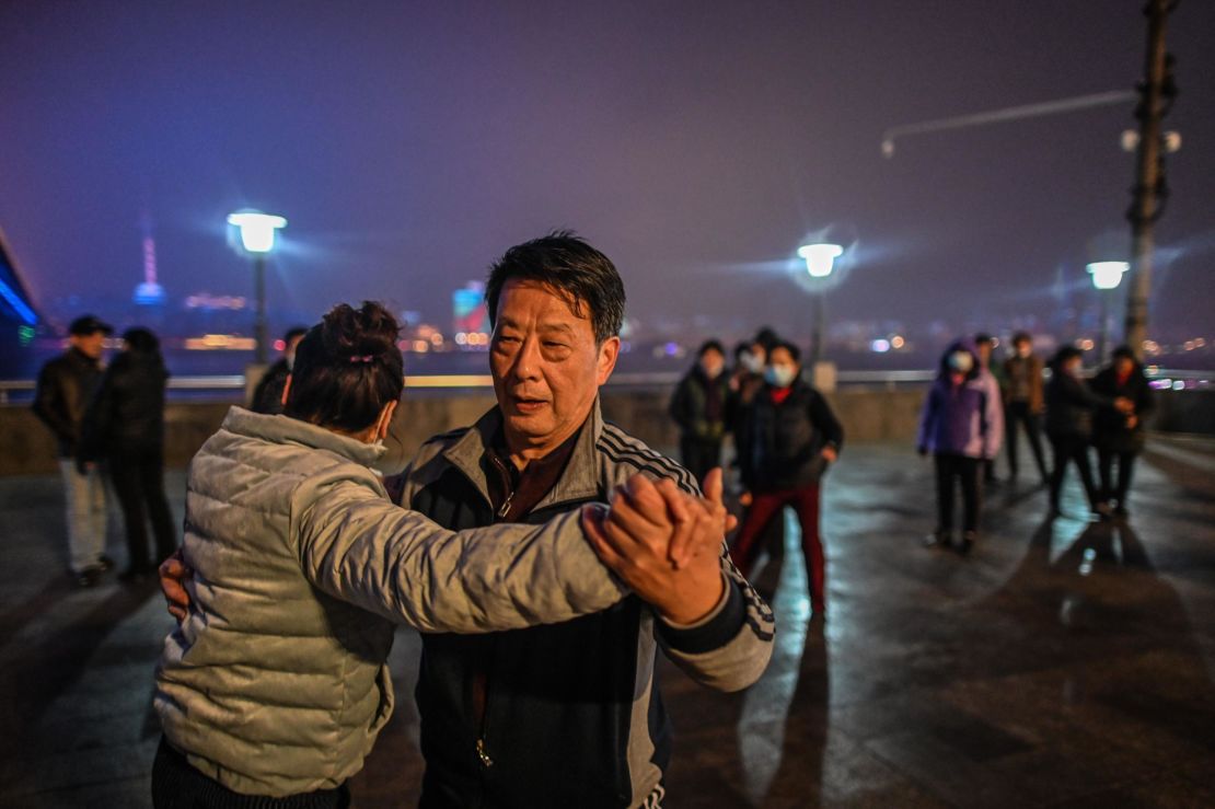 Elderly couples dance along the Yangtze River that cuts through the heart of Wuhan.