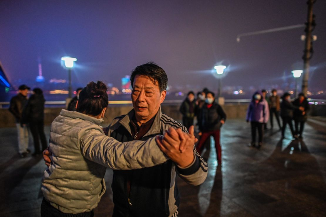 Elderly couples dance along the Yangtze River that cuts through the heart of the city.