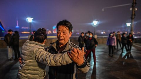 Elderly couples dance along the Yangtze River that cuts through the heart of the city.