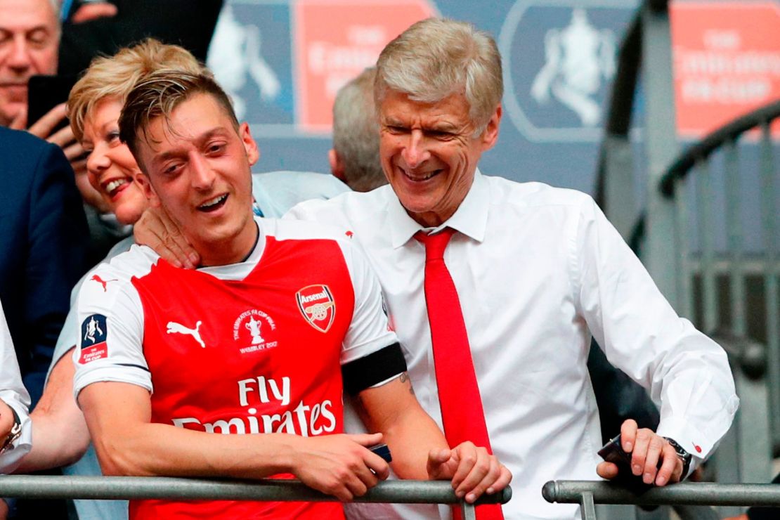 Ozil celebrates winning the FA Cup in 2017 alongside former Arsenal manager Arsene Wenger. 