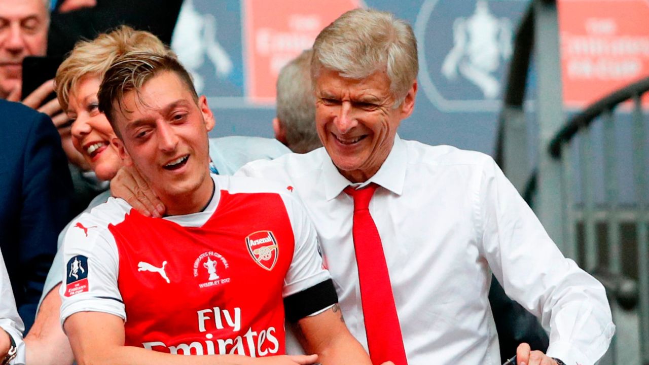 Ozil celebrates winning the FA Cup in 2017 alongside former Arsenal manager Arsene Wenger. 