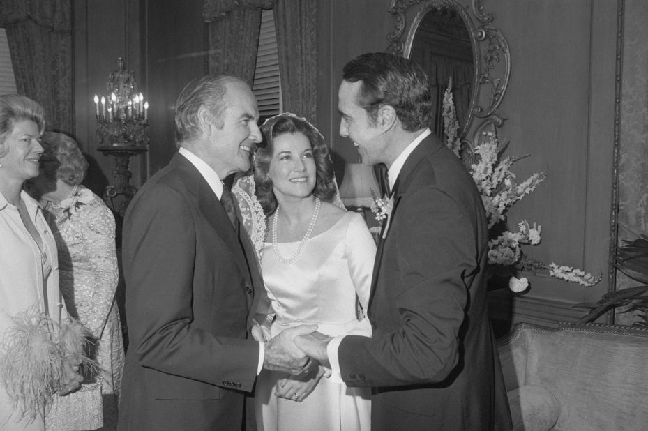 Dole, right, is congratulated by US Sen. George McGovern after his wedding in 1975. Dole's wife, Elizabeth, is seen at center.