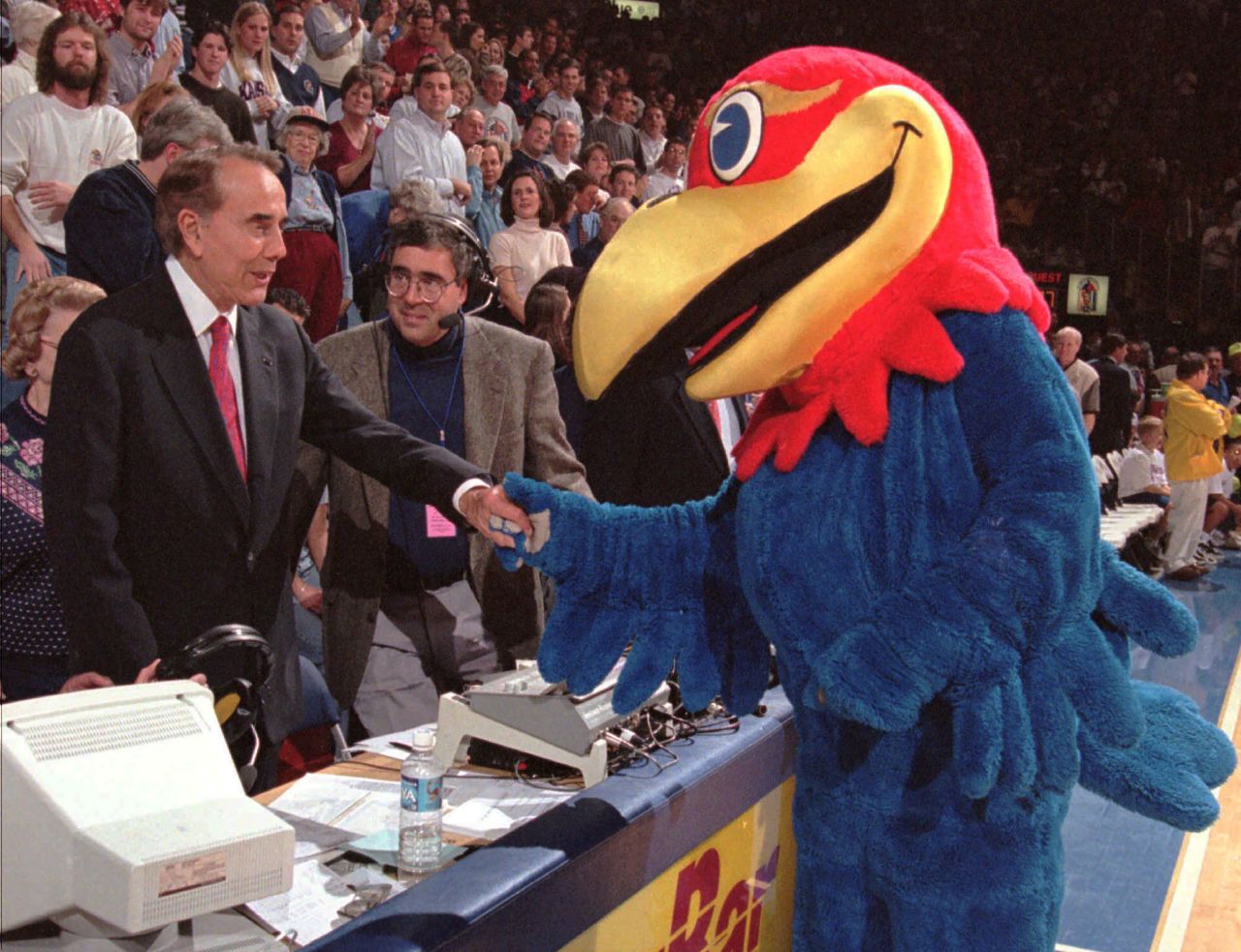 Dole shakes hands with the University of Kansas' mascot during a basketball game in 1998.