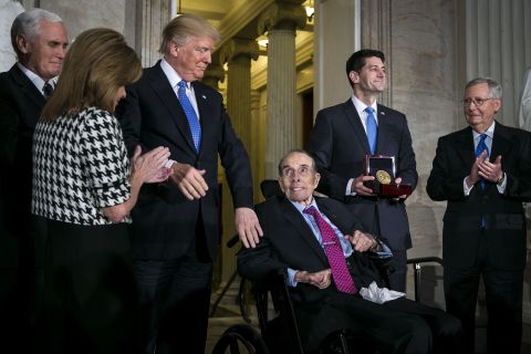 President Donald Trump greets Dole as House Speaker Paul Ryan holds Dole's Congressional Gold Medal in 2018. Trump honored Dole, calling the longtime Kansas lawmaker "a true American hero."
