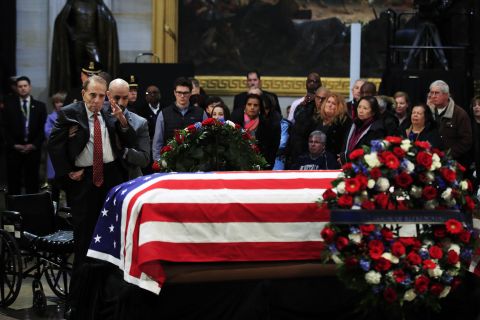 Dole salutes the flag-draped casket of former President George H.W. Bush at the US Capitol in 2018.