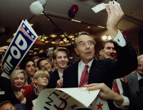 Dole takes a look at a $100 bill a supporter wanted signed at a campaign rally in Jacksonville, Florida, in 1996.
