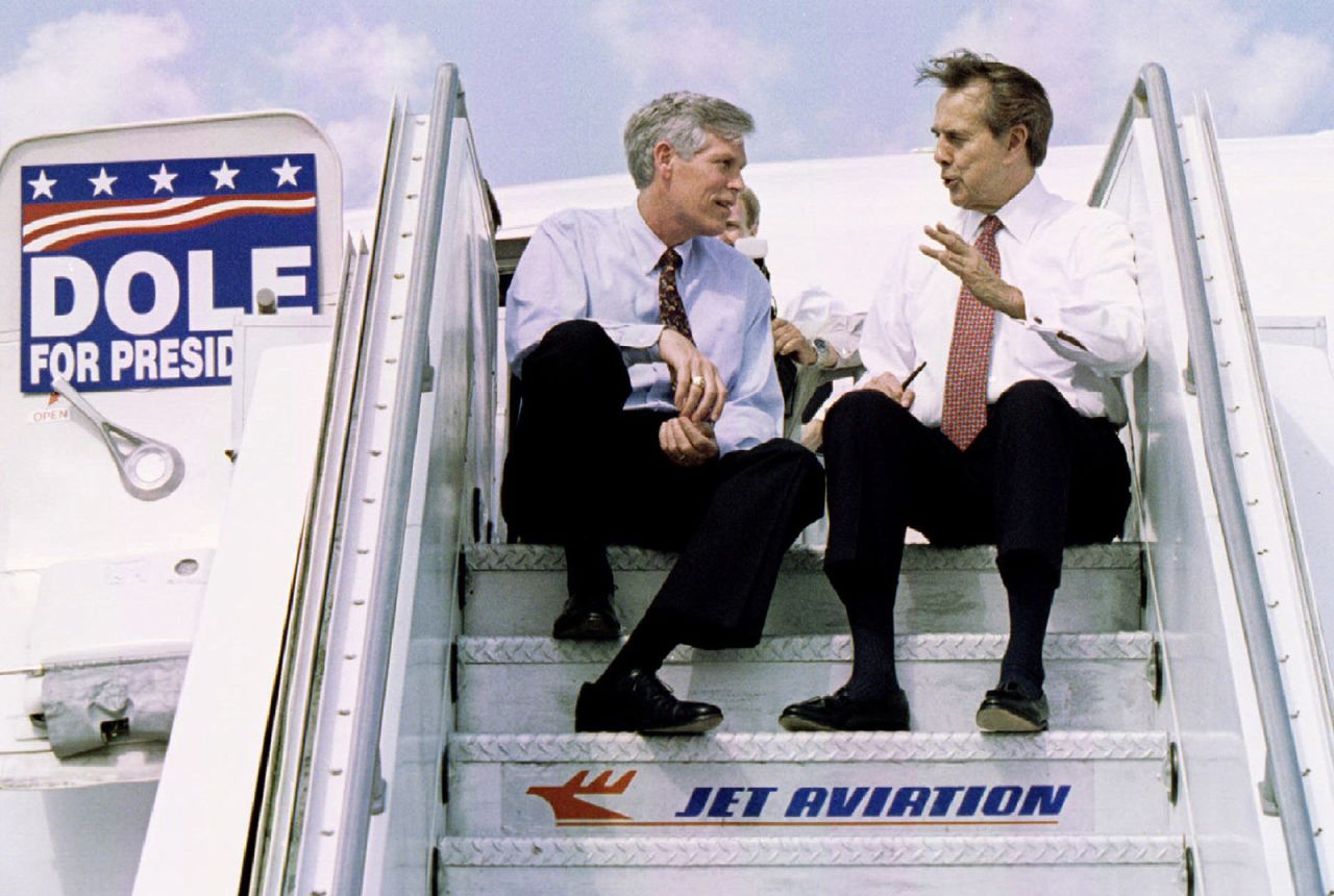 Dole speaks with US Sen. Connie Mack on the steps of an airplane following a campaign appearance in West Palm Beach, Florida, in 1996.