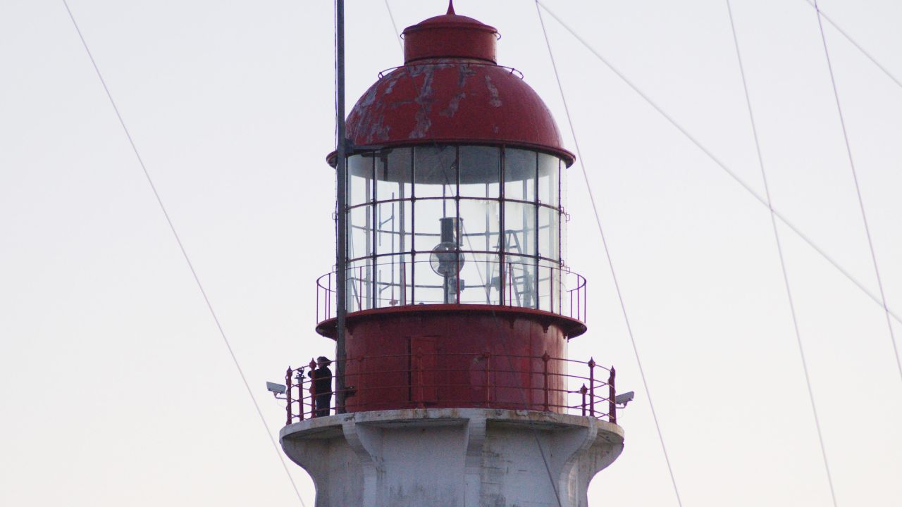 Caroline Woodward's husband Jeff George took this shot of Woodward working at Estevan Point lighthouse tower. She's visible on the left, removing the card from the sunlight recorder.