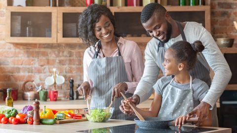 underscored black family cooking in kitchen
