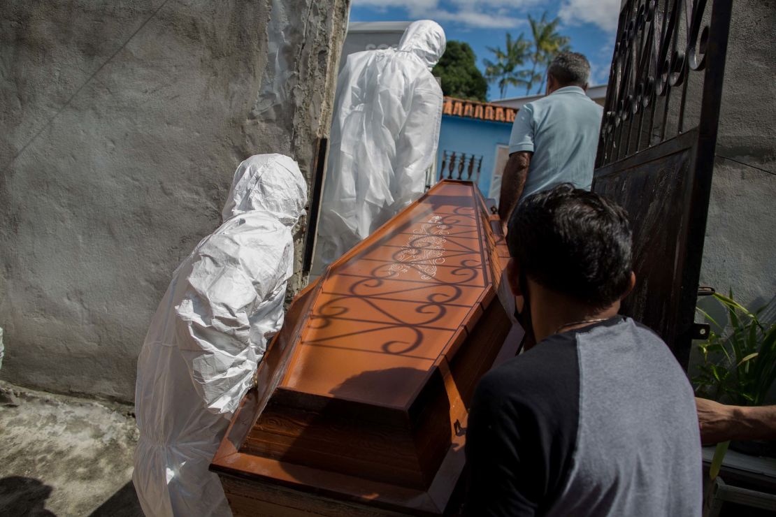 Municipal workers from SOS Funeral remove the body of 75-year-old Adamor Mendonca Maciel from his home in Manaus on January 16, 2021 after he died of COVID-19.