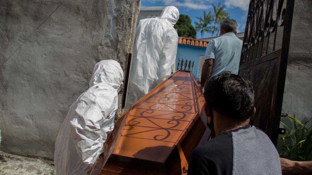 Municipal workers from SOS Funeral remove the body of 75-year-old Adamor Mendonca Maciel from his home in Manaus on January 16, 2021 after he died of COVID-19.