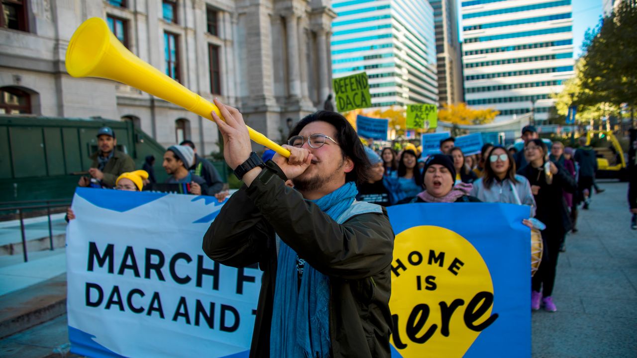 Glo Harn Choi, shown here leading a protest march in 2019, says years of physical labor have taken a toll on his mom.