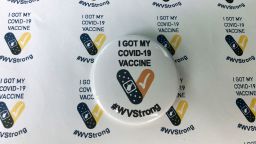 Stickers and a button given to people who receive their COVID-19 vaccines are displayed Thursday, Jan. 14, 2021, at the National Guard Armory in Charleston, W.Va. West Virginia has emerged an unlikely success in the nation's otherwise chaotic vaccine rollout. (AP Photo/John Raby)