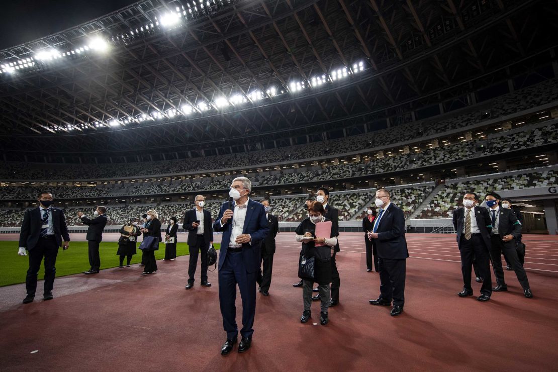International Olympic Committee President Thomas Bach, wearing a face mask, speaks to the media during a visit to the Japan National Stadium on November 17, 2020 in Tokyo.