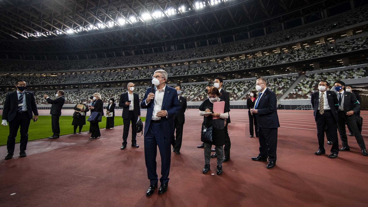 International Olympic Committee President Thomas Bach, wearing a face mask, speaks to the media during a visit to the Japan National Stadium on November 17, 2020 in Tokyo.