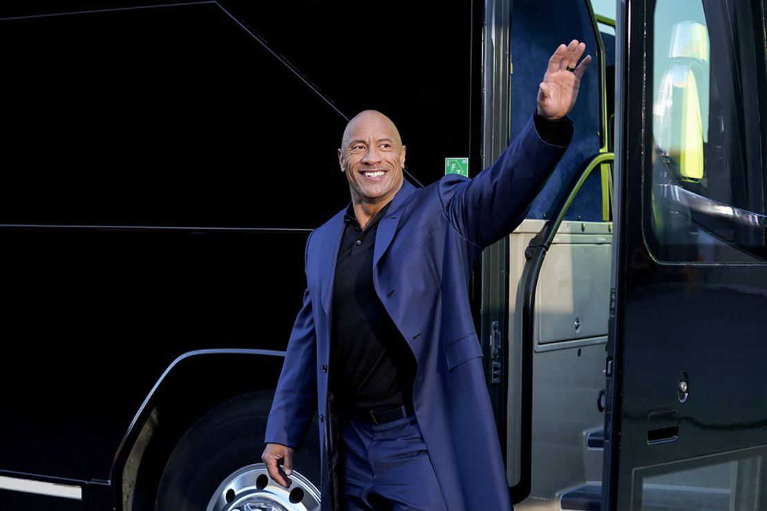 Dwayne Johnson waves to supporters in a scene from NBC's "Young Rock." 