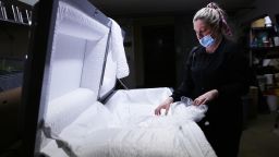 EL CAJON, CALIFORNIA - JANUARY 15: (EDITORIAL USE ONLY) Embalmer and funeral director Kristy Oliver unwraps a new casket which will be used for a person who died after contracting COVID-19 at East County Mortuary on January 15, 2021 in El Cajon, California. The mortuary on average was handling about 50 bodies per month but owner Robert Zakar believes they may process closer to 100 in January as California continues to see a spike in coronavirus deaths. The mortuary holds the bodies of those who pass away due to COVID-19 for a minimum of three days before they are processed along with various other COVID-related safety measures.  (Photo by Mario Tama/Getty Images)