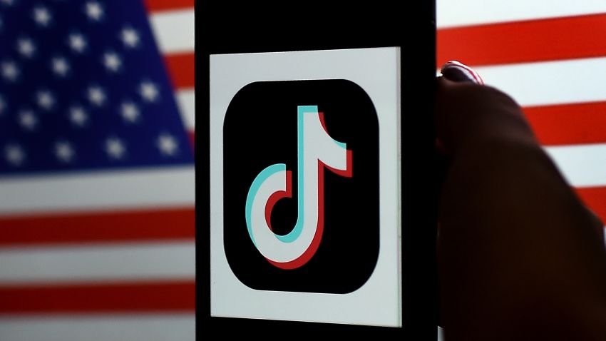 In this photo illustration, the social media application logo, TikTok is displayed on the screen of an iPhone on an American flag background on August 3, 2020 in Arlington, Virginia. - President Donald Trump said Monday that Chinese-owned hugely popular video-sharing app TikTok will be "out of business" in the United States if not sold to a US firm by September 15, 2020."I set a date of around September 15, at which point it's going to be out of business in the United States," he told reporters. (Photo by Olivier DOULIERY / AFP) (Photo by OLIVIER DOULIERY/AFP via Getty Images)