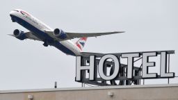 A British Airways Boeing 787 Dreamliner airplane is seen flying over a hotel at Heathrow Airport in west London on January 26, 2021. - The British government is being urged to beef up its borders policy as several countries around the world tighten travel rules over fears of new strains of the novel coronavirus. Ministers have for weeks been mulling whether to require all incoming travellers to isolate in hotels, and a decision is expected within days. (Photo by JUSTIN TALLIS / AFP) (Photo by JUSTIN TALLIS/AFP via Getty Images)