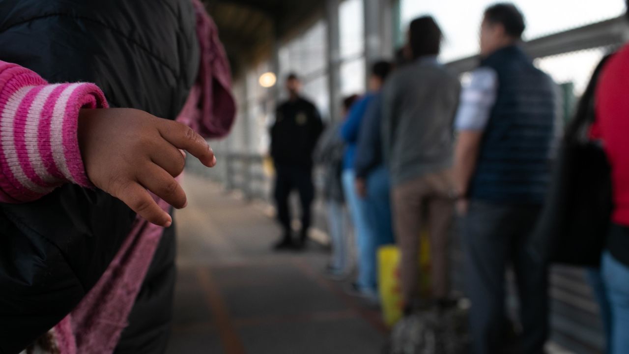 A young Honduran asylum seeker waits with her family on the international bridge next to the border town of Matamoros, Mexico. 