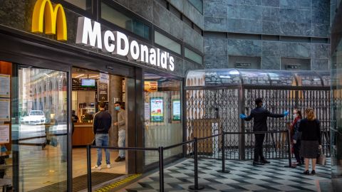A customer has her temperature checked as she stands in line to enter a McDonald's Corp. restaurant in Milan, Italy, on Monday, May 18, 2020.