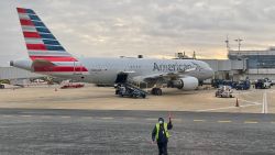 An airport employee gestures on the tarmac as an American Airlines Airbus 220 plane is seen at gate at Washington National Airport (DCA) in Arlington, Virginia on December 18, 2020. (Photo by Daniel Slim/AFP/Getty Images)