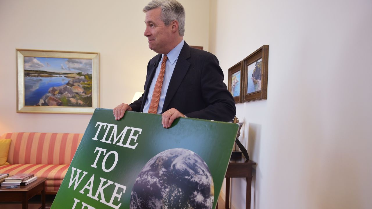 Sen. Sheldon Whitehouse holding his "Time to Wake Up" photo. 