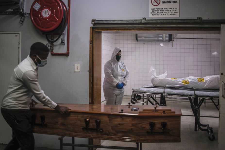 A morgue attendant, right, stands next to the body of a Covid-19 victim in Pretoria, South Africa, on January 22.
