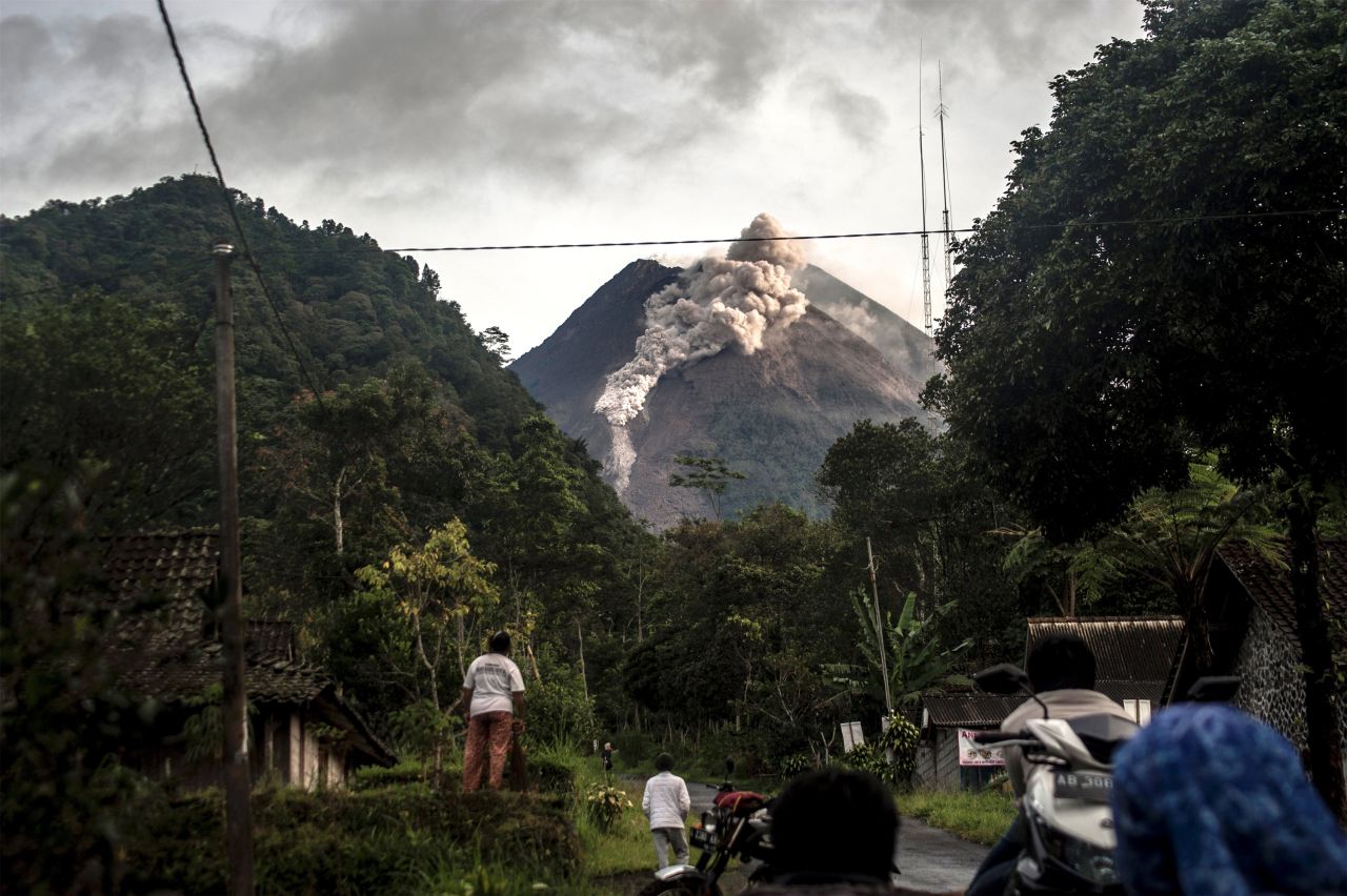 People look up at Mount Merapi, Indonesia's most active volcano, as it spews rocks and ash in Yogyakarta on Wednesday, January 27. 