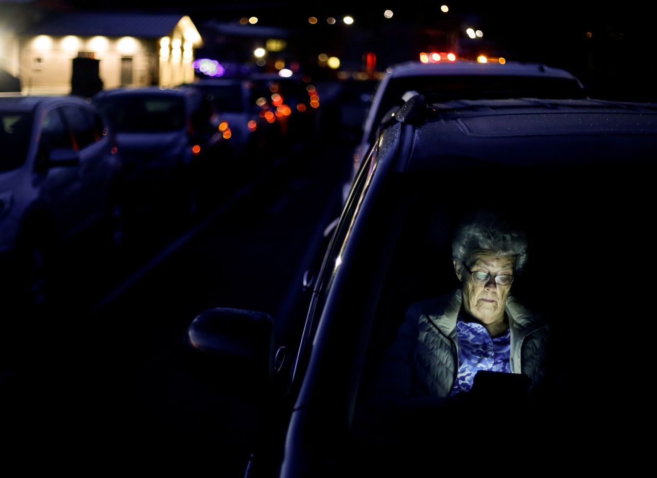 Betty Nelson reads her tablet in her vehicle while waiting for a Covid-19 vaccine clinic to open in Sequim, Washington, early on Saturday, January 23.