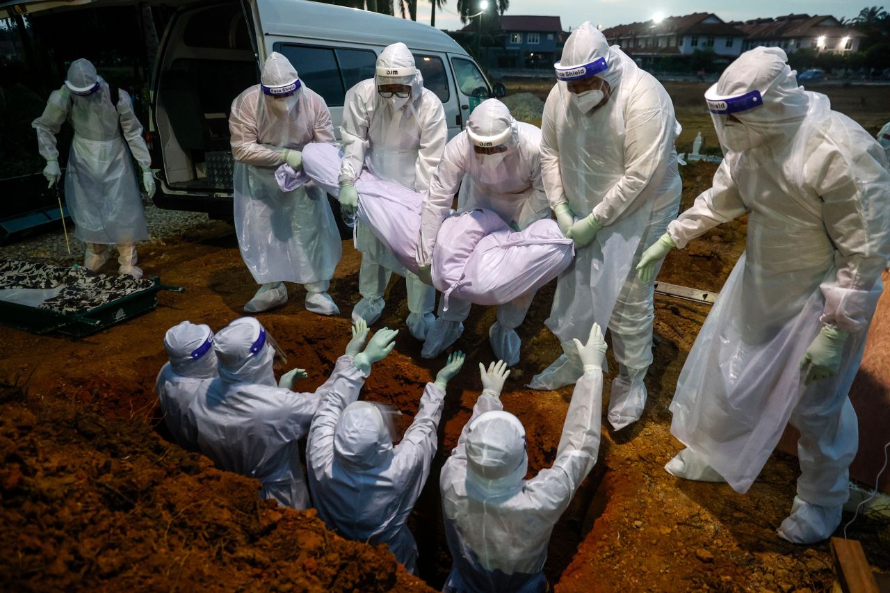 Workers bury a Covid-19 victim in Kuala Selangor, Malaysia, on Monday, January 25.