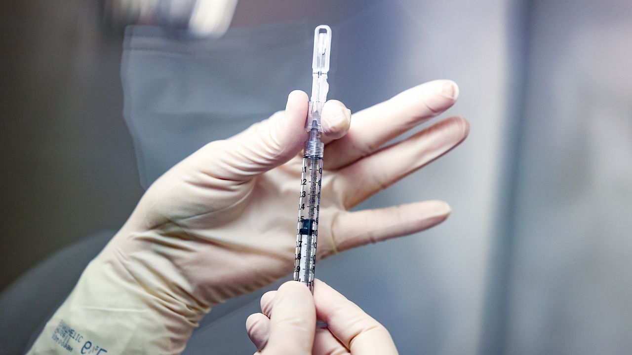 A VA medical tech prepares a vaccine dose. 