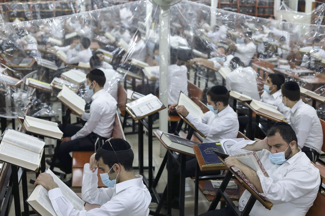 Ultra-Orthodox Jewish men study in a hall divided with plastic sheets to protect against Covid-19 in Bnei Brak on October 25, 2020.
