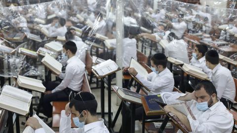 Ultra-Orthodox Jewish men study in a hall divided with plastic sheets to protect against Covid-19 in Bnei Brak on October 25, 2020.