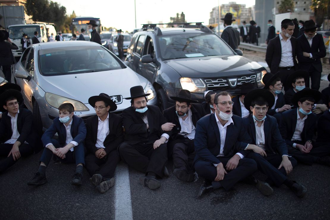 Ultra-Orthodox Jews block a road in Bnei Brak during a demonstration staged moments before Israel entered a third nationwide lockdown on December 27.