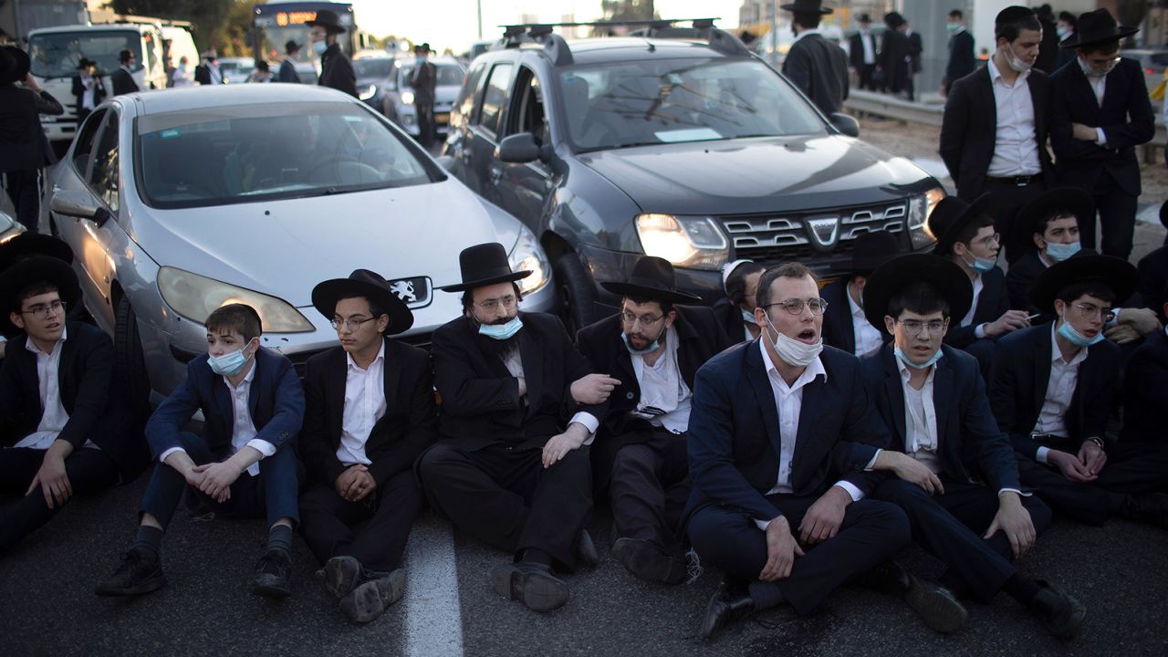 Ultra-Orthodox Jews block a road in Bnei Brak during a demonstration staged moments before Israel entered a third nationwide lockdown on December 27.