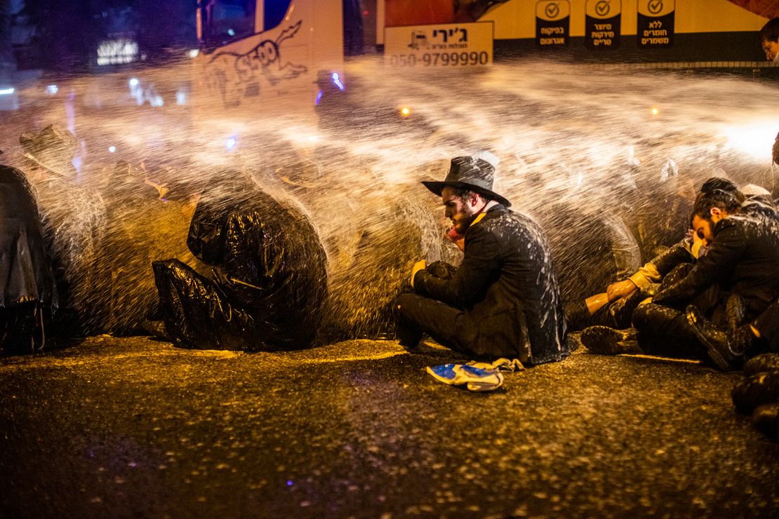 Israeli policemen use water cannon to disperse an anti-lockdown demonstration staged in Bnei Brak by ultra-Orthodox Jews on December 27.