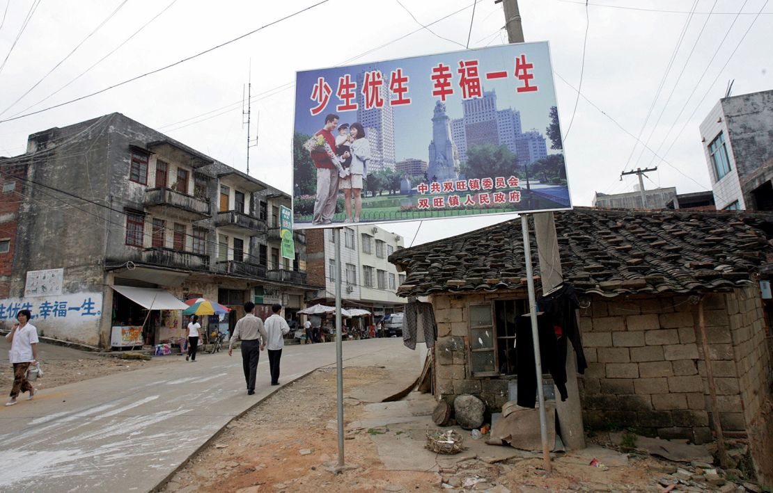 A one-child policy billboard saying, "Have less children, have a better life" greets residents on the main street of Shuangwang in southern China in 2007. 