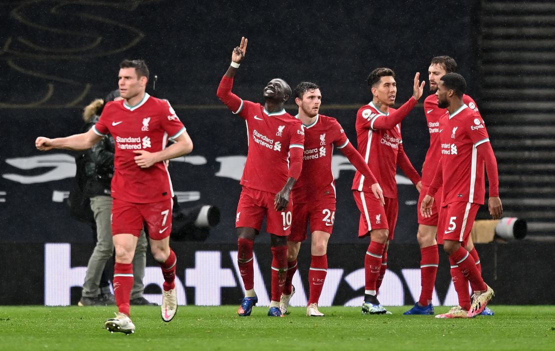 Mane celebrates with Andrew Robertson and teammates after he scores his sides third goal against Tottenham.