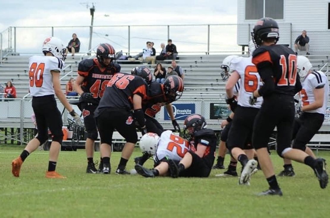 Spencer, here on the ground after making a tackle, enjoyed team events and the camaraderie of football. 