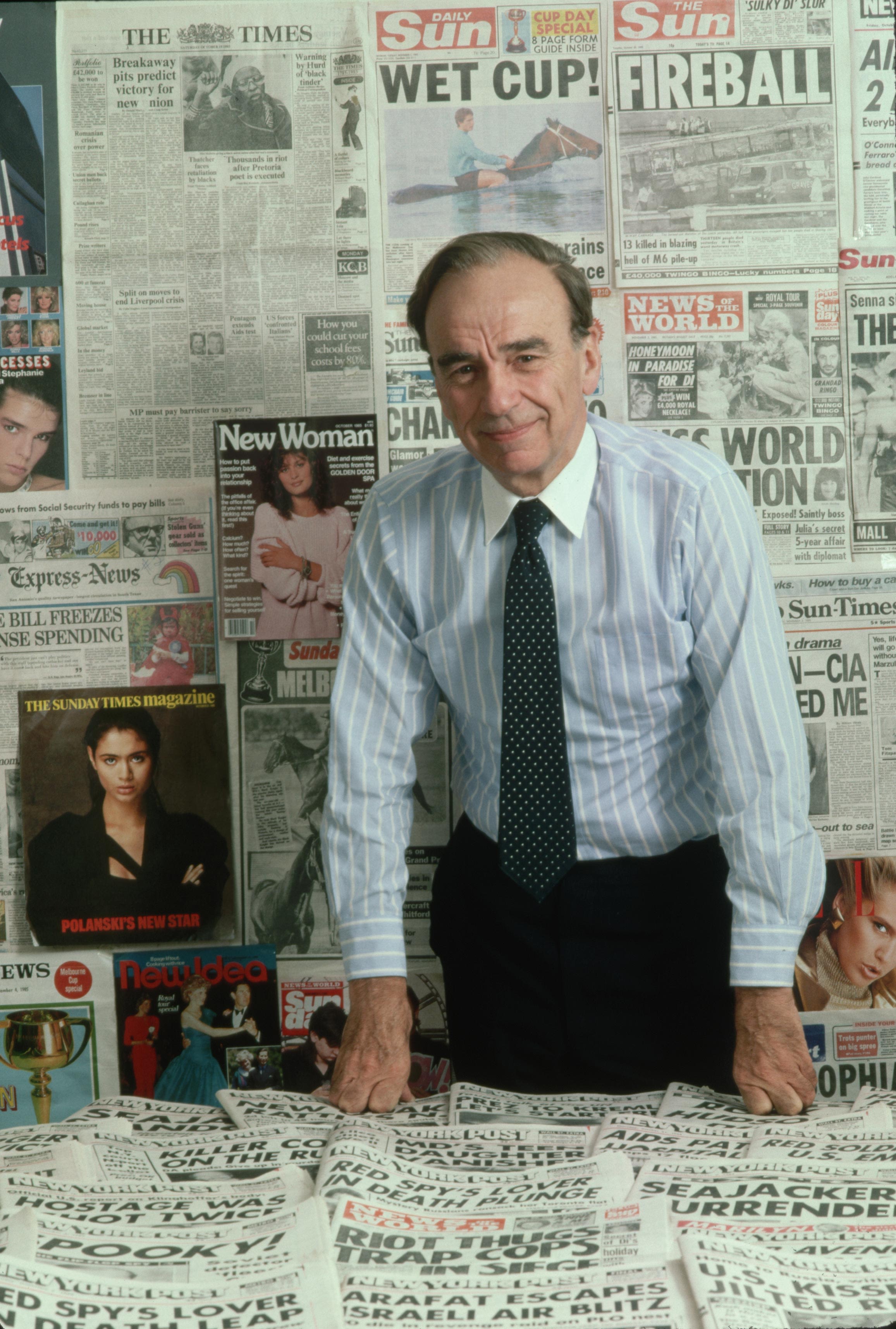 Murdoch poses in front of newspapers and magazines at the New York Post offices in 1985.