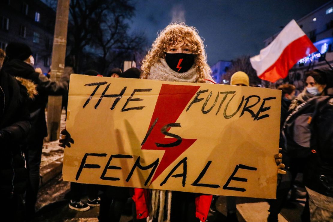 Weronika, 22, holds a banner with the Women's Strike symbol.