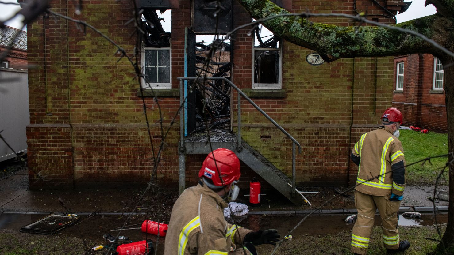 Firefighters inspect the charred remains of a block at Napier Barracks in Folkestone, England, on January 30, 2021 