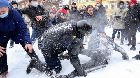 A policeman detains a man while protesters try to help him, during a protest in St. Petersburg on Sunday against the detention of opposition leader Alexey Navalny.