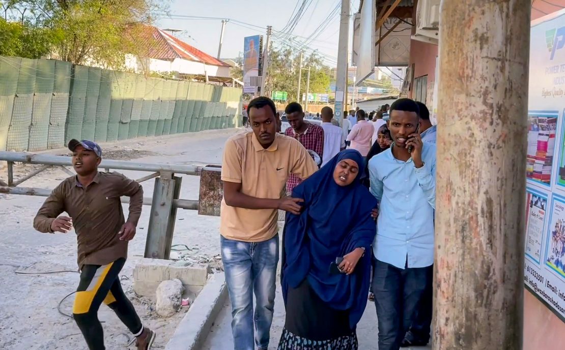 People flee as gunshots are heard on a street near the Afrik hotel in Mogadishu