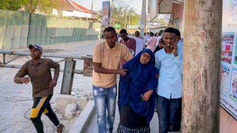 People flee as gunshots are heard on a street near the Afrik hotel in Mogadishu